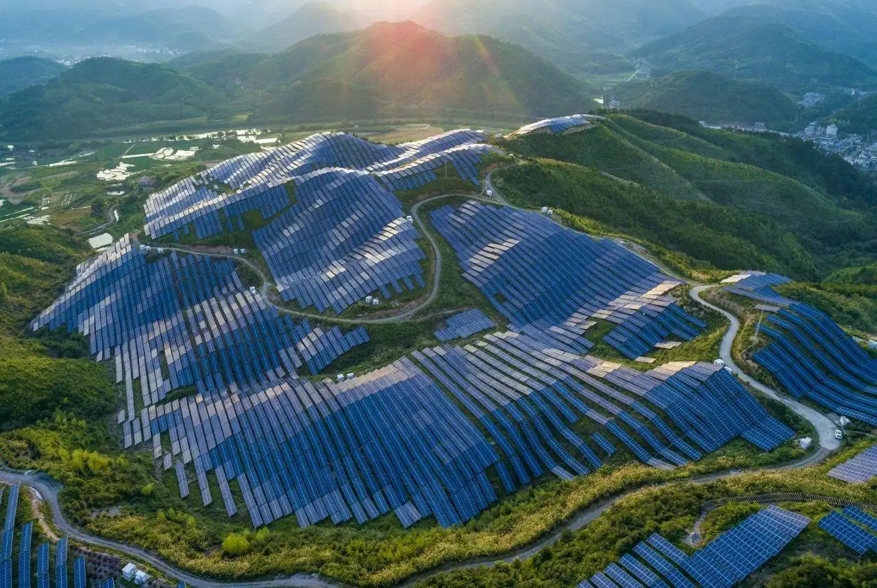Aerial view of a hillside utility-scale solar farm at sunrise (representative image)